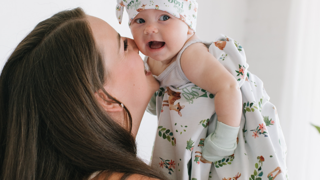 Mom holding up her baby and laughing together
