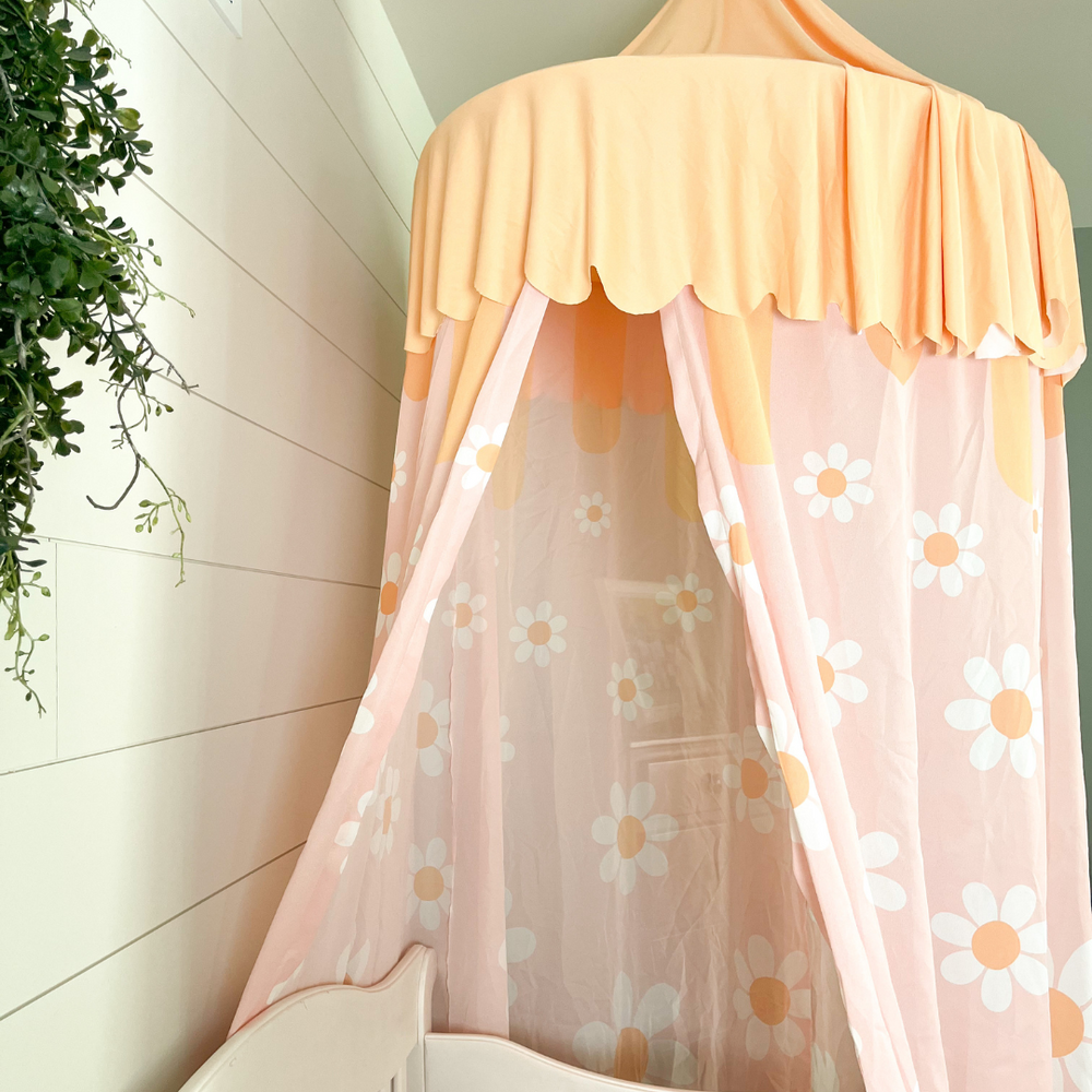 a bed with a pink canopy and flowers on it