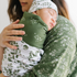 Mother holding a baby wrapped in a green and white floral-patterned swaddle wrap personalized with baby name.